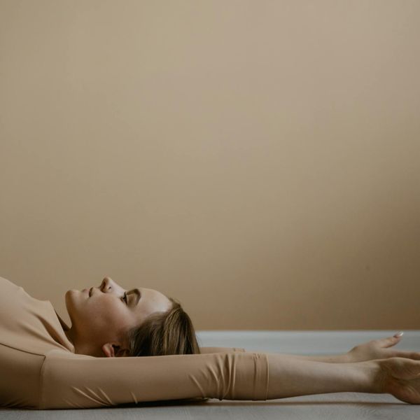 A child laughing while trying to balance on one leg in a yoga class.