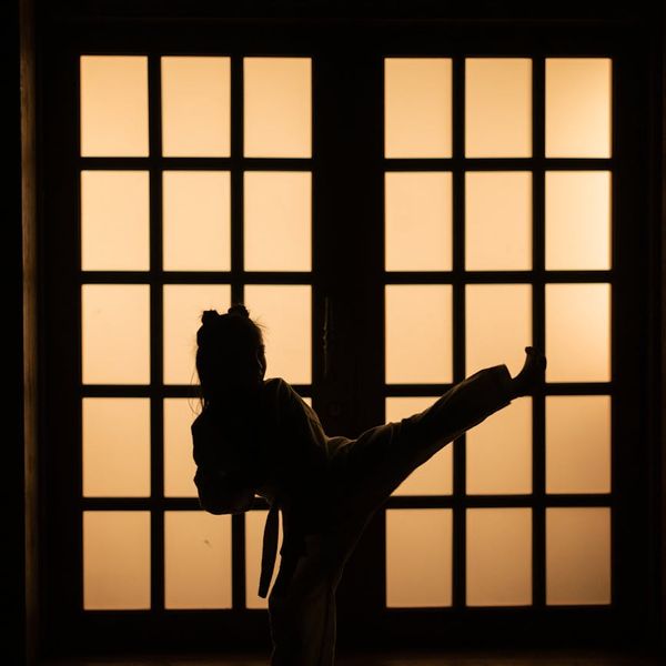 A silhouette of a child balancing during sunset, showing concentration.