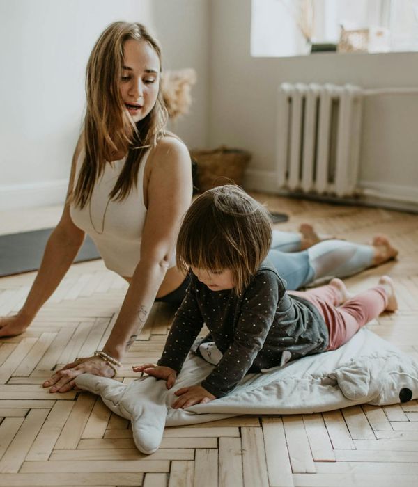 Happy children doing a simple yoga pose in a bright, playful room.